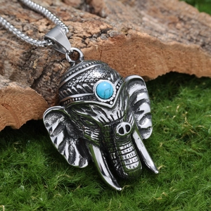 Gros plan du pendentif éléphant vintage en acier inoxydable avec pierre turquoise et mousse