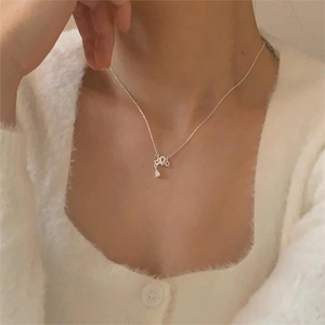 Close-up of elegant crown and teardrop zircon pendant necklace on woman's neck