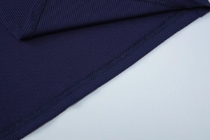 Close-up of dark blue ribbed knit fabric showing flat overlock stitching and texture