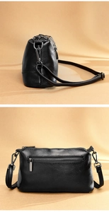 Detail view of black lychee leather bag showing side metal buckle and back zipper pocket