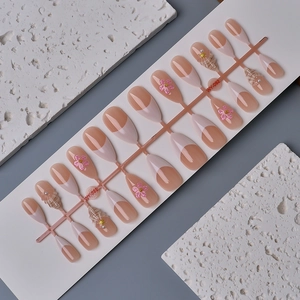 French nude almond press-on nails with 3D white flowers, pearls, and golden accents