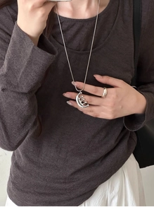 Detailed view of a silver minimalist comb pendant necklace paired with a matching open ring