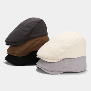 Flat lay of vintage cotton ivy caps in charcoal, brown, black, cream, and light grey
