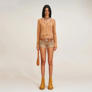 Dettaglio del cardigan in maglia slim e micro shorts in denim invecchiato con accessori in metallo