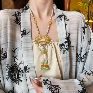 Detail of Chinese style pearl necklace with gold lock pendant and elegant tassels