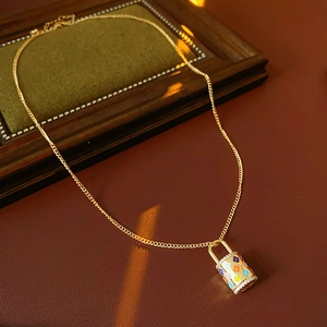 Detailed macro view of vintage gold necklace with floral pattern padlock pendant