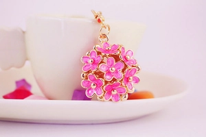 Detailed macro of pink enamel flower cluster pendant with gold metal edges