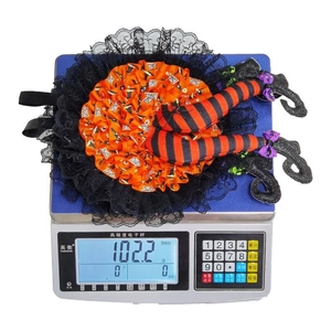 Detail showing 102.2g weight of Halloween witch leg wreath with orange lace and pumpkin