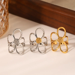 Three hollow daisy rings in silver and gold steel finishes on a ripple glass display