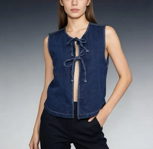 Close-up of dark blue lace-up denim vest with sleeveless design and lace ties
