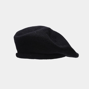 Detail view of black knit beret showing textured wool fabric and rolled edge finish