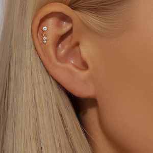 Detailed view of a gold 925 silver cartilage stud with three vertical sparkling zircons