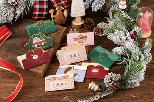 Detailed view of 3D folding Christmas cards with festive envelopes on a rustic wooden table