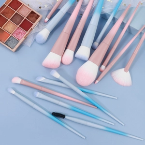Vue à plat d'un set de pinceaux maquillage dégradé rose bleu aux poils synthétiques doux
