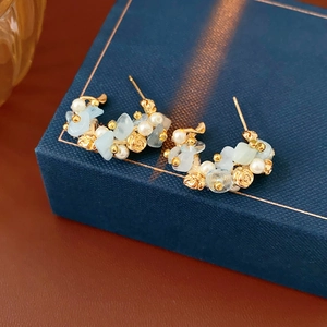Detail of floral C-shape earring with aquamarine stones, pearls and golden roses