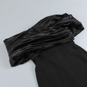 Detail of the black elegant evening dress with satin crossover pleated off-shoulder neckline