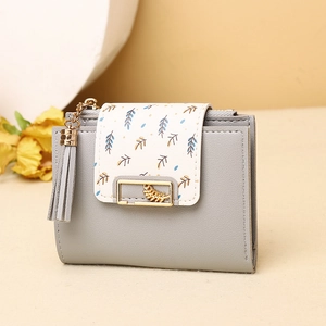 Close-up of light grey bifold wallet with gold leaf clasp and elegant tassel detail