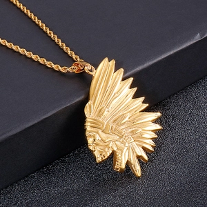 Close-up of golden Indian head pendant with twisted rope chain on black texture