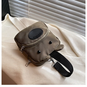 Gros plan du sac en nylon vert armée avec yeux de dessin animé et plusieurs fermetures