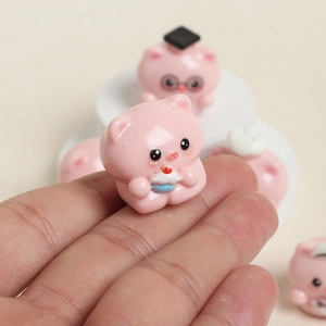 Macro shot of a cute pink resin pig holding a cupcake for DIY crafts and decor