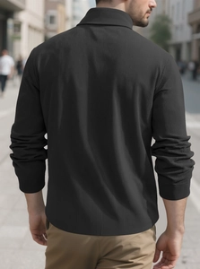 Close-up of black ribbed long-sleeve polo shirt featuring a classic collar and texture