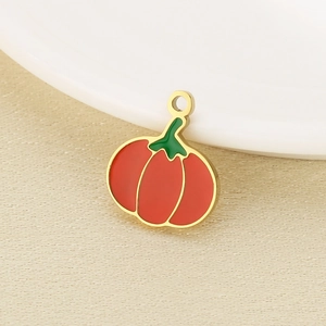 Makroaufnahme eines kürbisförmigen Emaille-Anhängers in Orange und Gold für DIY-Schmuck