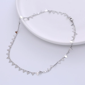 Modern minimalist stainless steel necklace with geometric triangle charms on a white plate