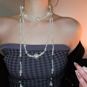 Detail view of multilayer pearl necklace with oversized beads and elegant layering