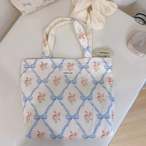 Flat lay of floral canvas tote bag with blue bow patterns and simple wish brand label