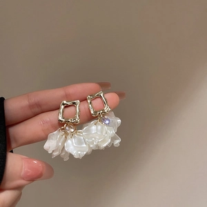 Détail de boucles d'oreilles en argent 925 avec pétales de perles et pierres colorées