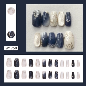 Faux ongles bleu marine et champagne avec texture marbrée et détails en feuille d'or