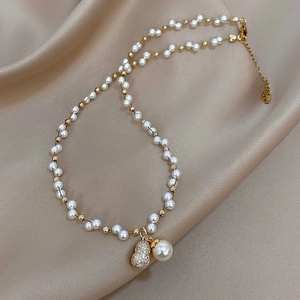 French vintage pearl necklace with sparkling zircon gourd pendant on silk background