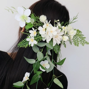 Elegant white floral bridal hairpiece with artificial flowers and green trailing leaves