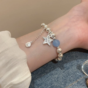 Detailed shot of beaded star bracelet with blue bead and shine engraved pendant