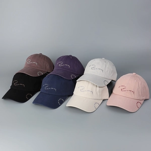 Detail showing seven colors of cotton baseball caps with side alphabet embroidery