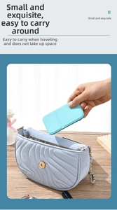Close-up of a mint green portable makeup mirror being placed into a blue quilted bag