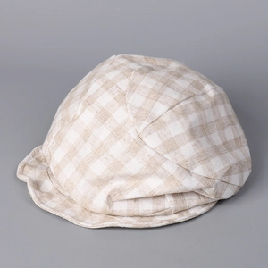 Close-up of beige and white plaid texture on breathable cotton linen beret hat