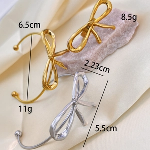 Polished 18K gold and silver bow cuff bracelet for women in minimalist style