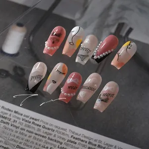 Detailed view of 5D pink and black nail art stickers with faux pearls and script text