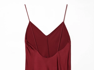Detail of burgundy satin dress showing delicate V-neck and thin spaghetti straps