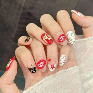 Red star and lip print press-on nails with 3D gold studs and artistic patterns