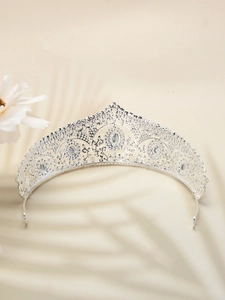 Close-up of vintage silver bridal crown with sparkling clear rhinestones on beige background