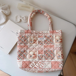 Close-up of quilted floral cotton tote bag with bunny patterns and simple wish label