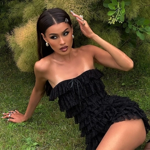 Detail of black strapless lace dress with tiered ruffles and intricate floral texture