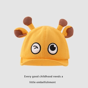 Détail du bonnet en tricot pour bébé avec cornes 3D et broderie d'yeux de dessin animé