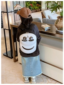 Detail of a 3D cartoon face design on a lightweight black and white kids' backpack