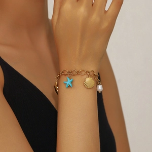 Detail of 18K gold starfish and pearl charms on a stylish ocean-themed bracelet