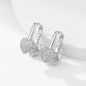 Detail of silver heart-shaped hoop earrings featuring shimmering pave zircon settings