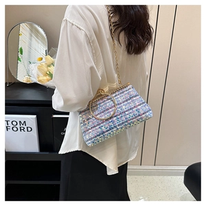 Detail of tweed crossbody bag with sequins and golden round handle over light blue and pink