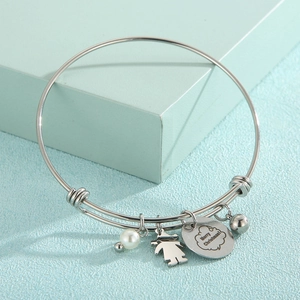 Détail du bracelet argenté avec perle, pendentif fille et breloque Merry Christmas poli
